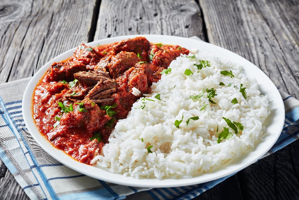 African beef stew in tomato sauce with spices and Peacock rice